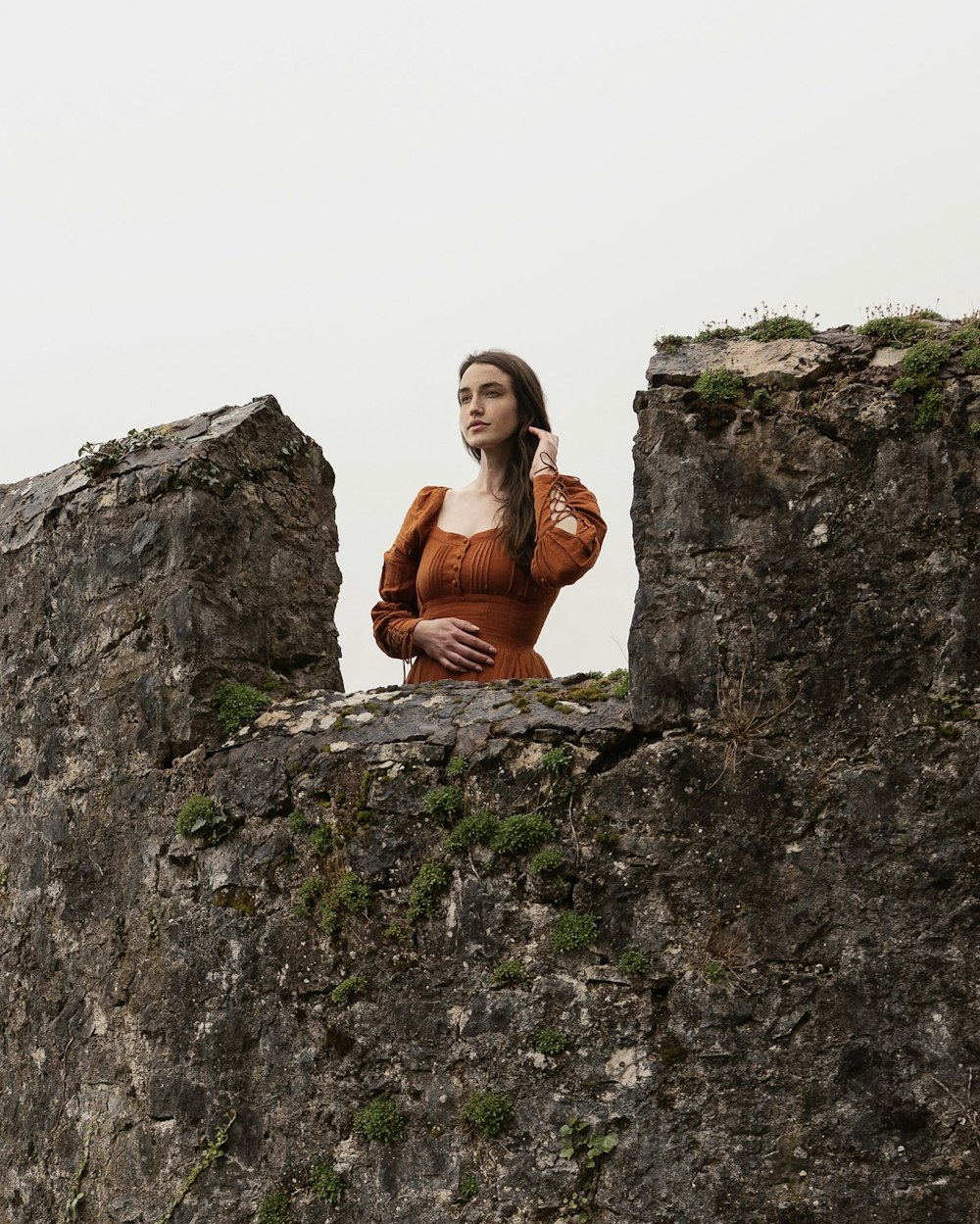 女性が岩の上に座って携帯電話で話している