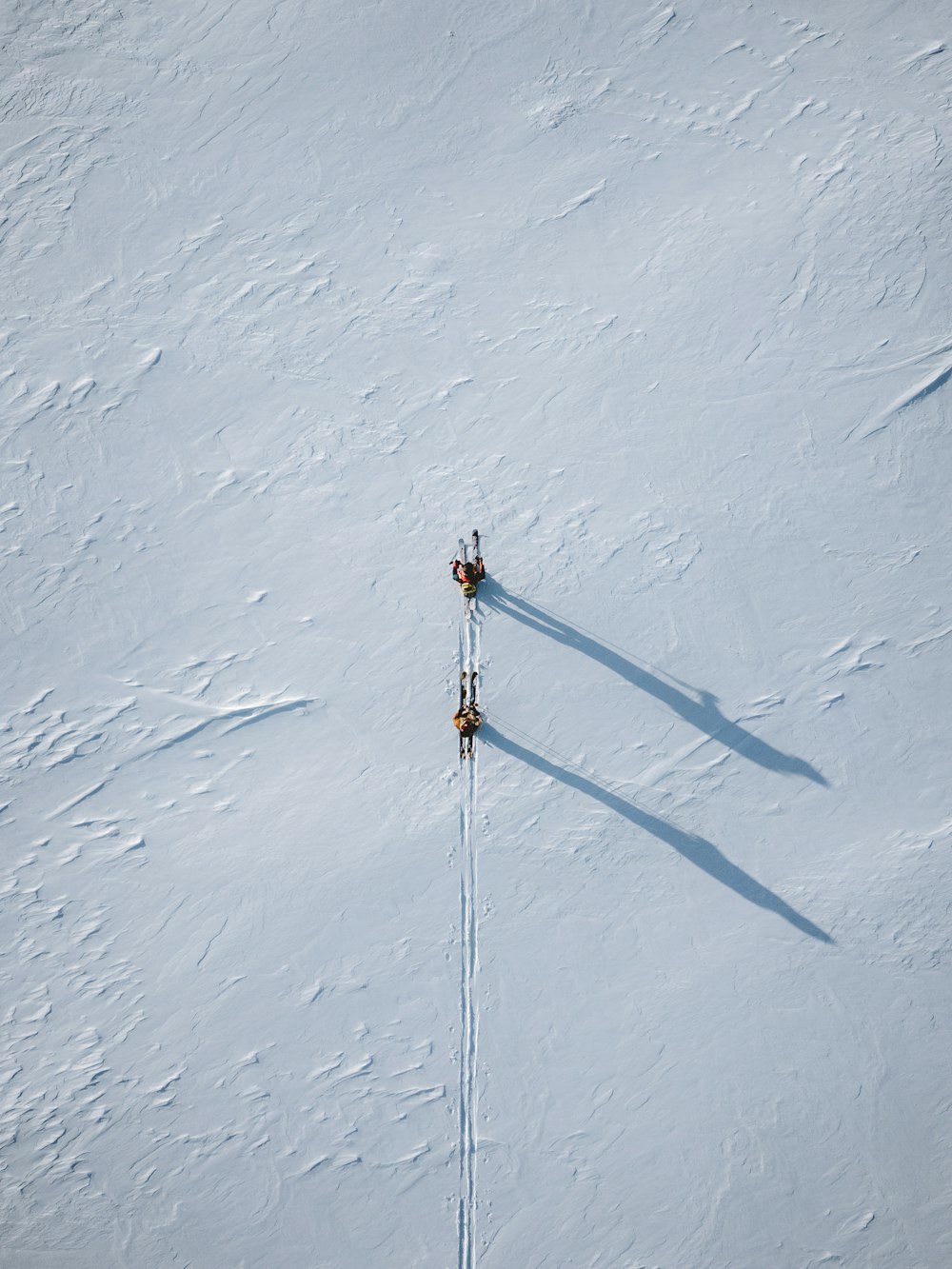 two people are skiing down a snowy hill