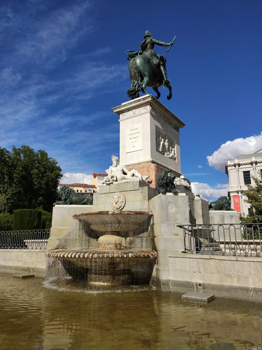 a statue of a man riding a horse next to a fountain