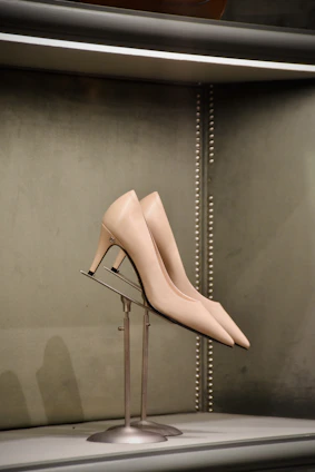 Close-up of elegant women's shoes in soft pastel colors displayed on a delicate fabric background