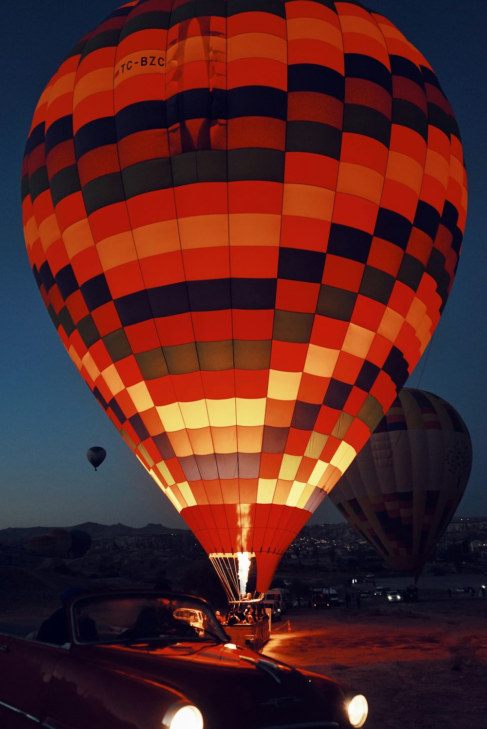 a hot air balloon with a car in the foreground