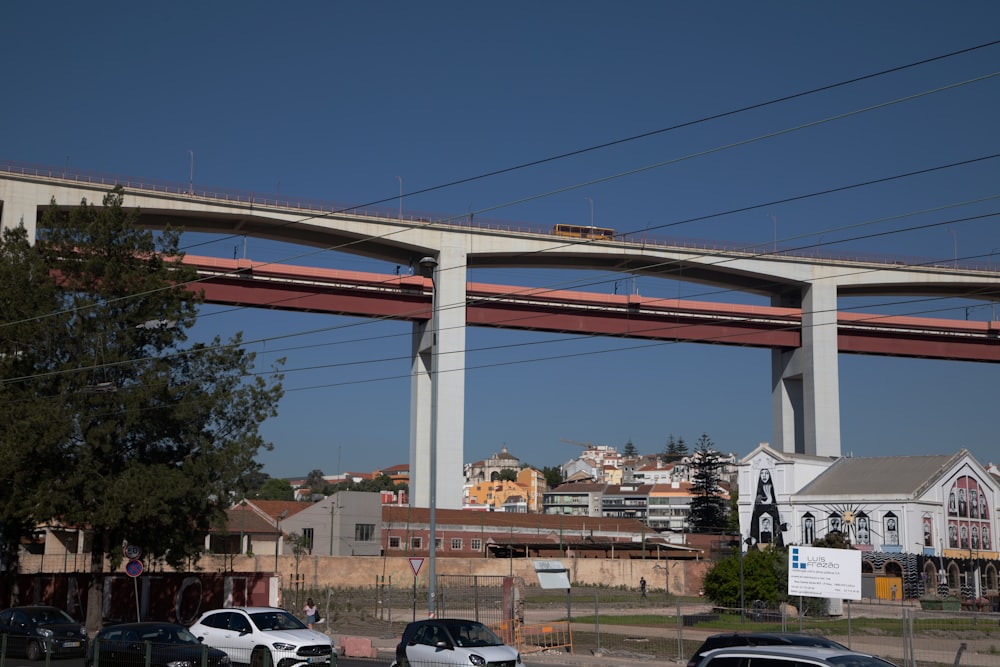 cars are parked on the side of the road under a bridge