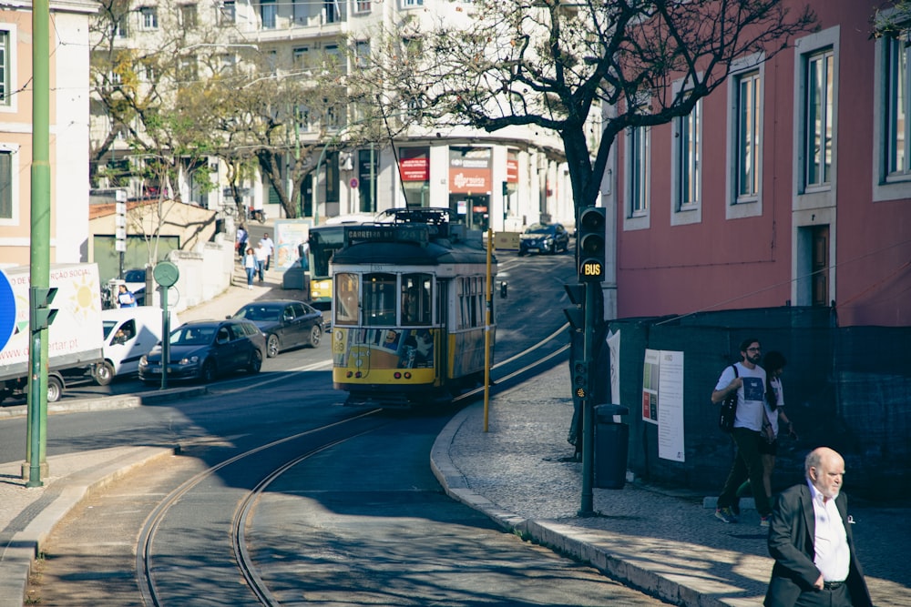 a yellow trolley is coming down the street