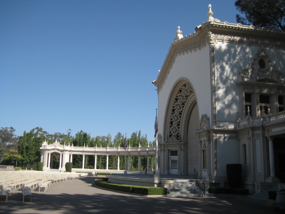 a large white building sitting next to a lush green park