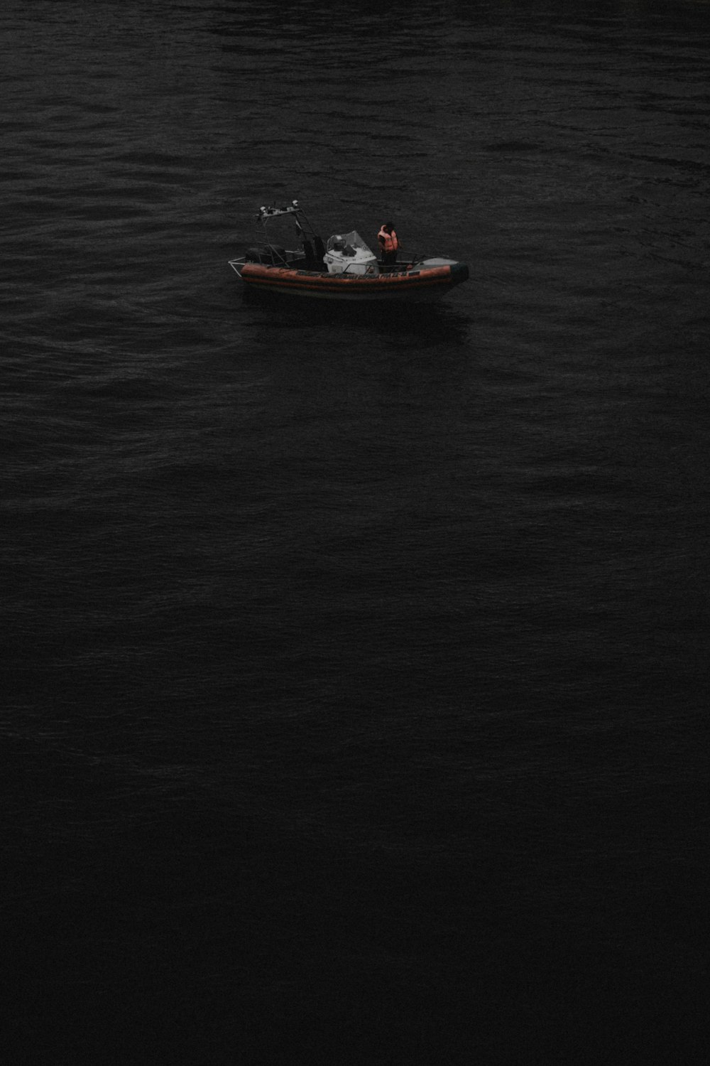 a small boat floating on top of a large body of water