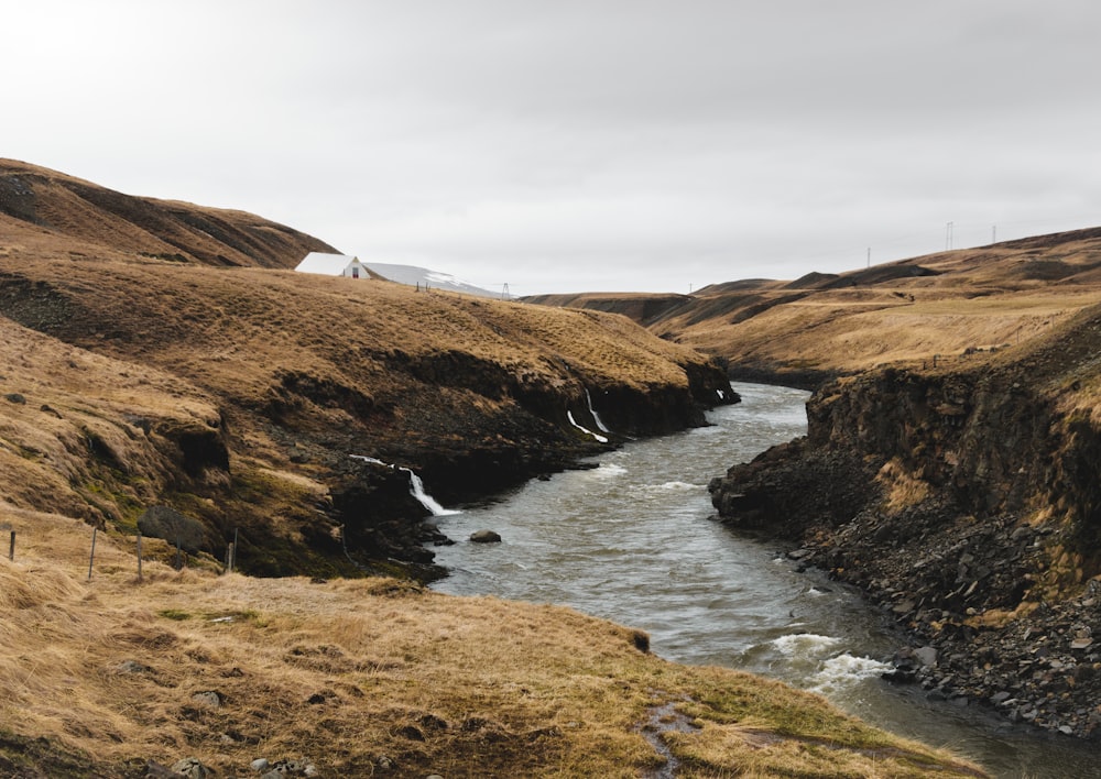 a river running through a lush green hillside