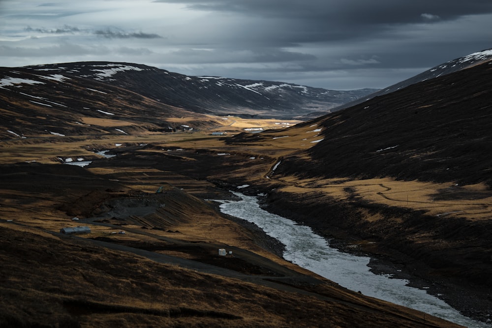 a river running through a valley surrounded by mountains