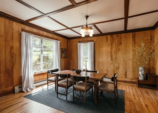 a dining room with wood paneling and windows
