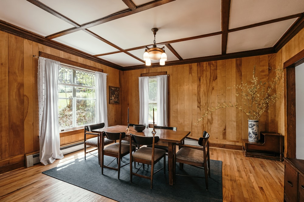 a dining room with wood paneling and windows