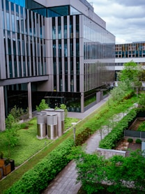 a building with a lot of windows next to a lush green field