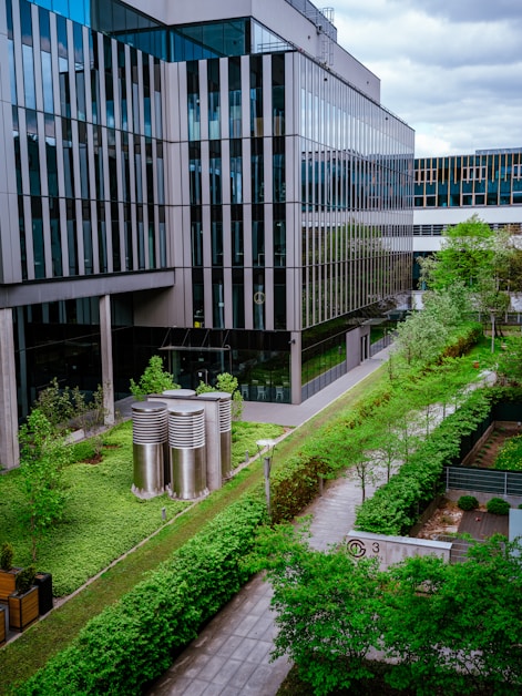 a building with a lot of windows next to a lush green field