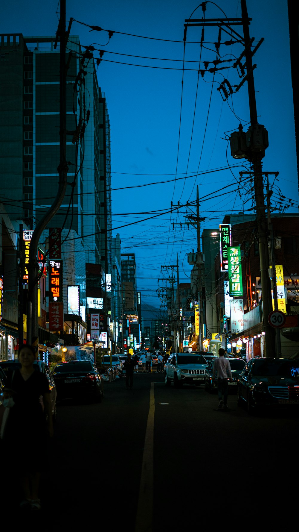 a busy city street at night with cars and people