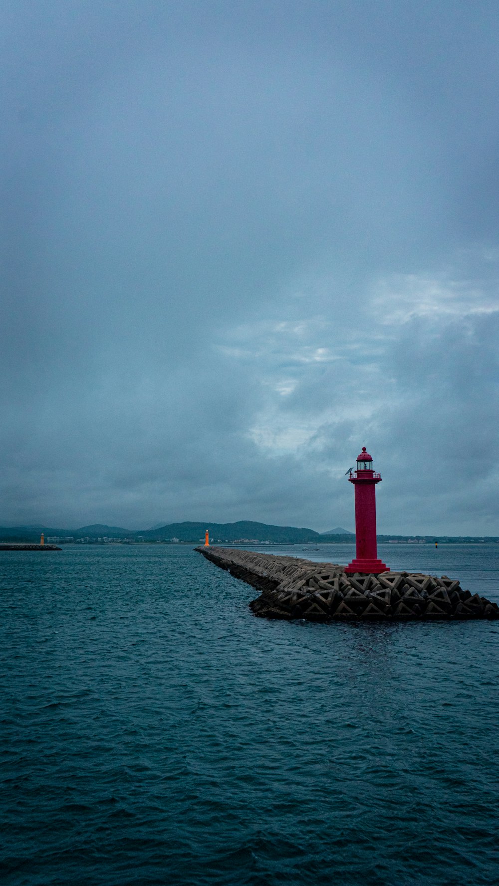 a red and white lighthouse sitting on top of a pier