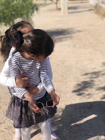 Playful kids wearing stylish outfits in a sunny park.