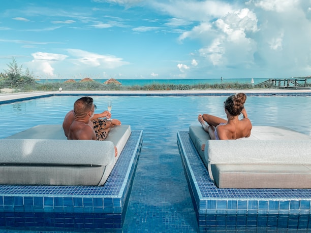 Couple relaxing by a luxurious all-inclusive hotel pool in Mexico.