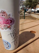 Sleek custom 20oz tumblers with colorful designs on a wooden table.