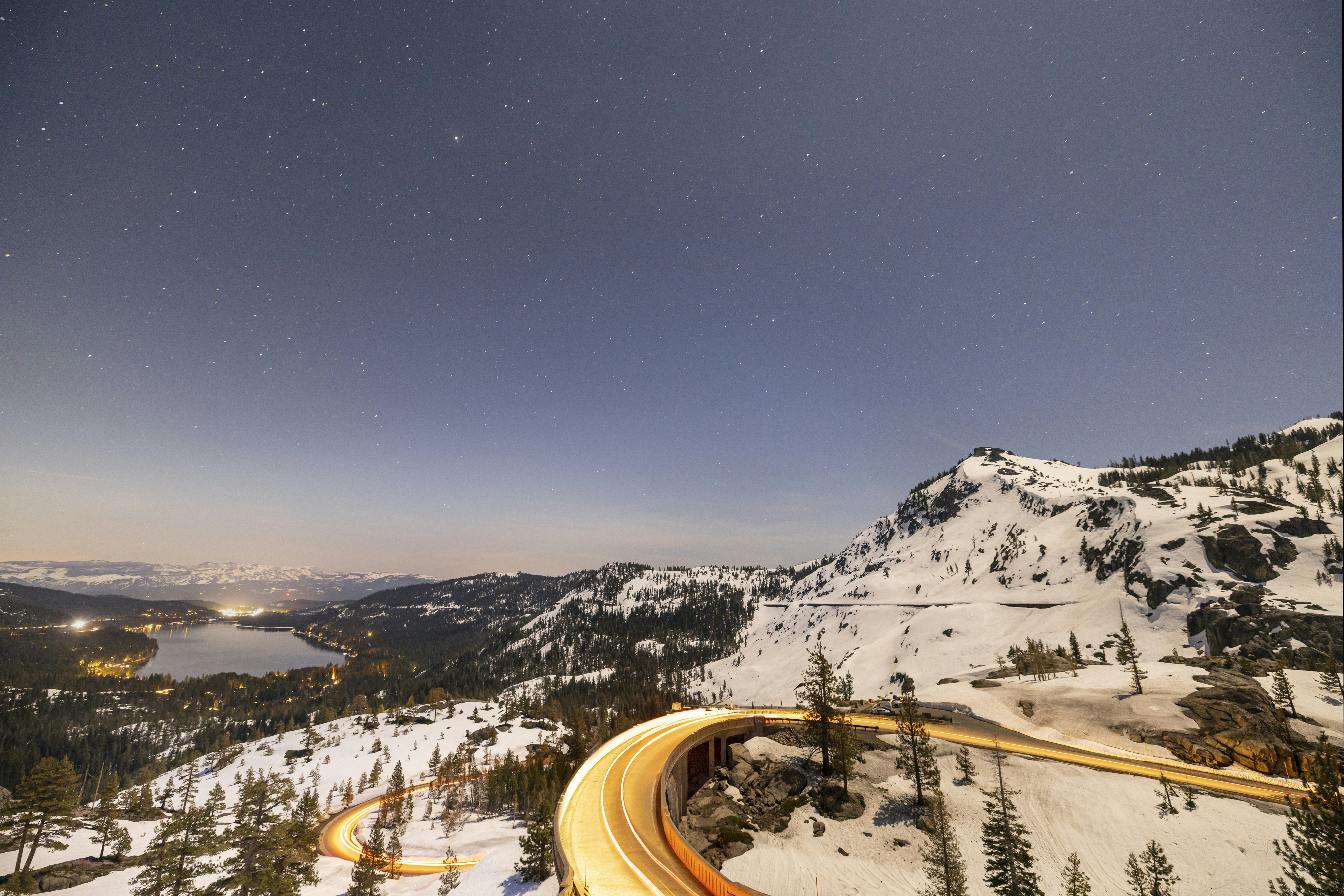 a night time view of a mountain with a road going through it