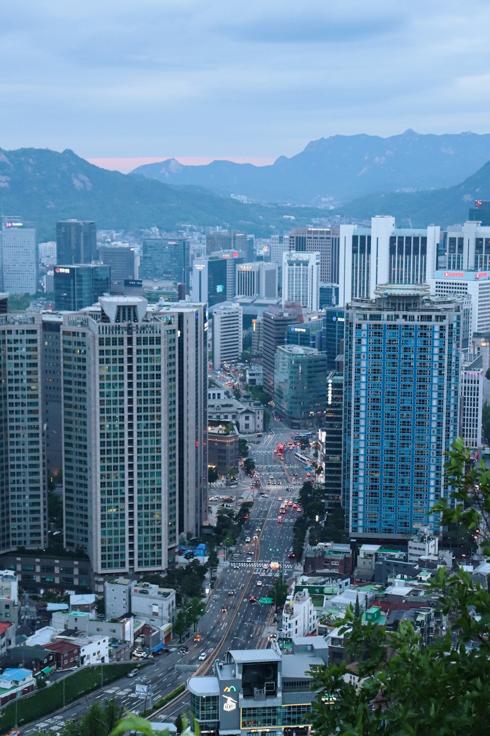 a view of a city with tall buildings and mountains in the background