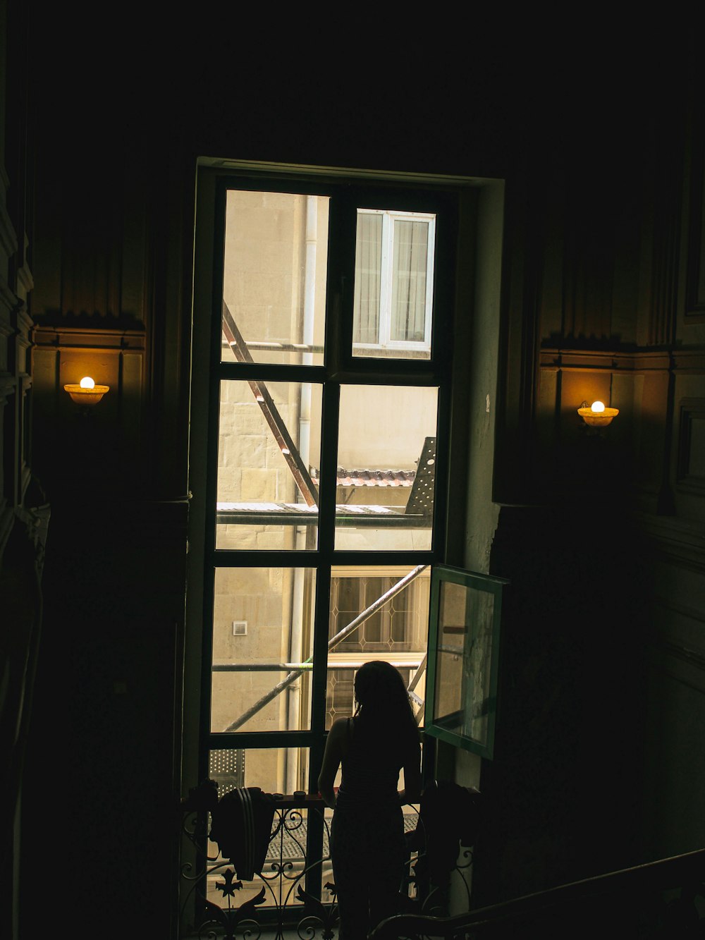 a person standing in front of a window in a dark room