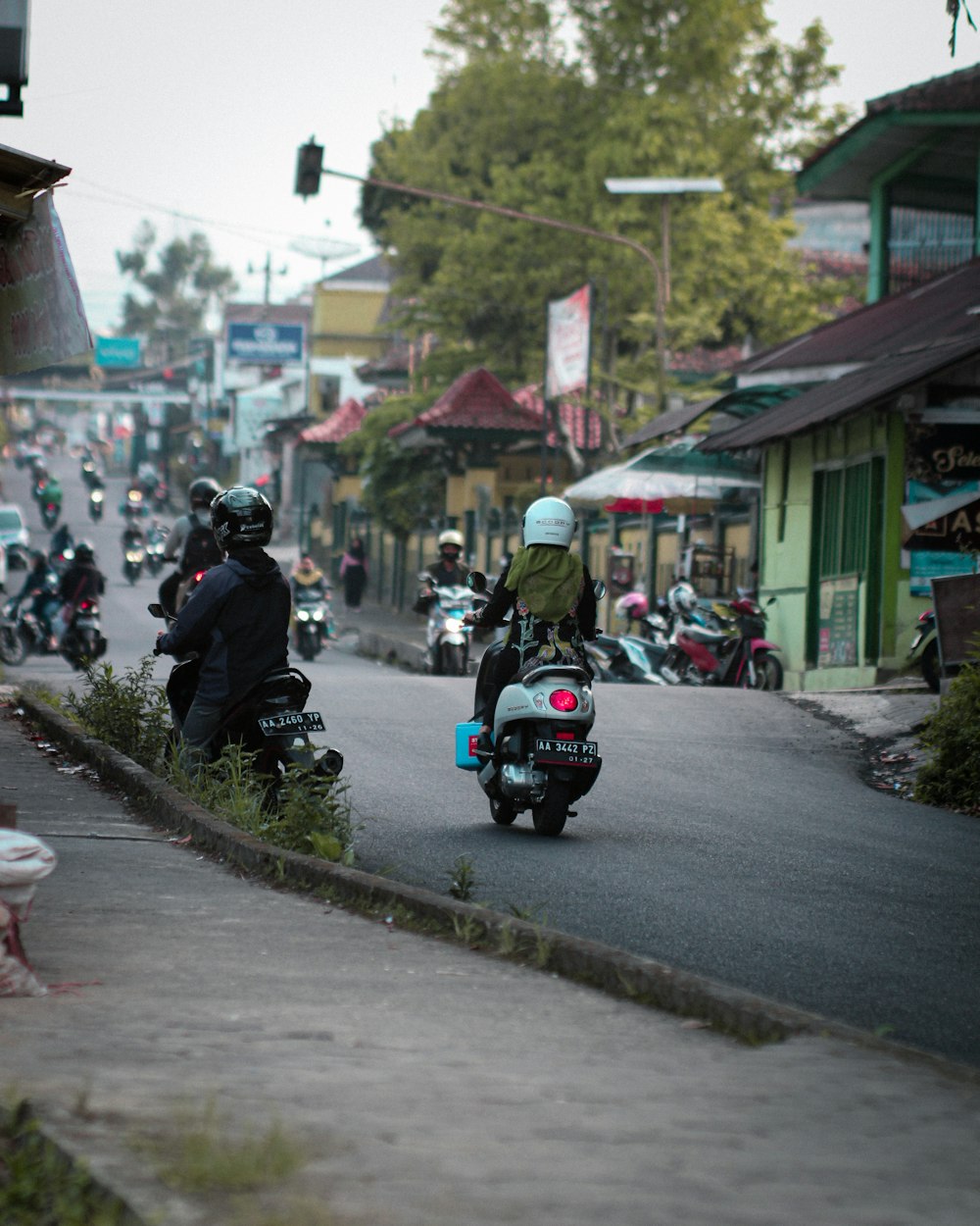 a group of people riding motorcycles down a street