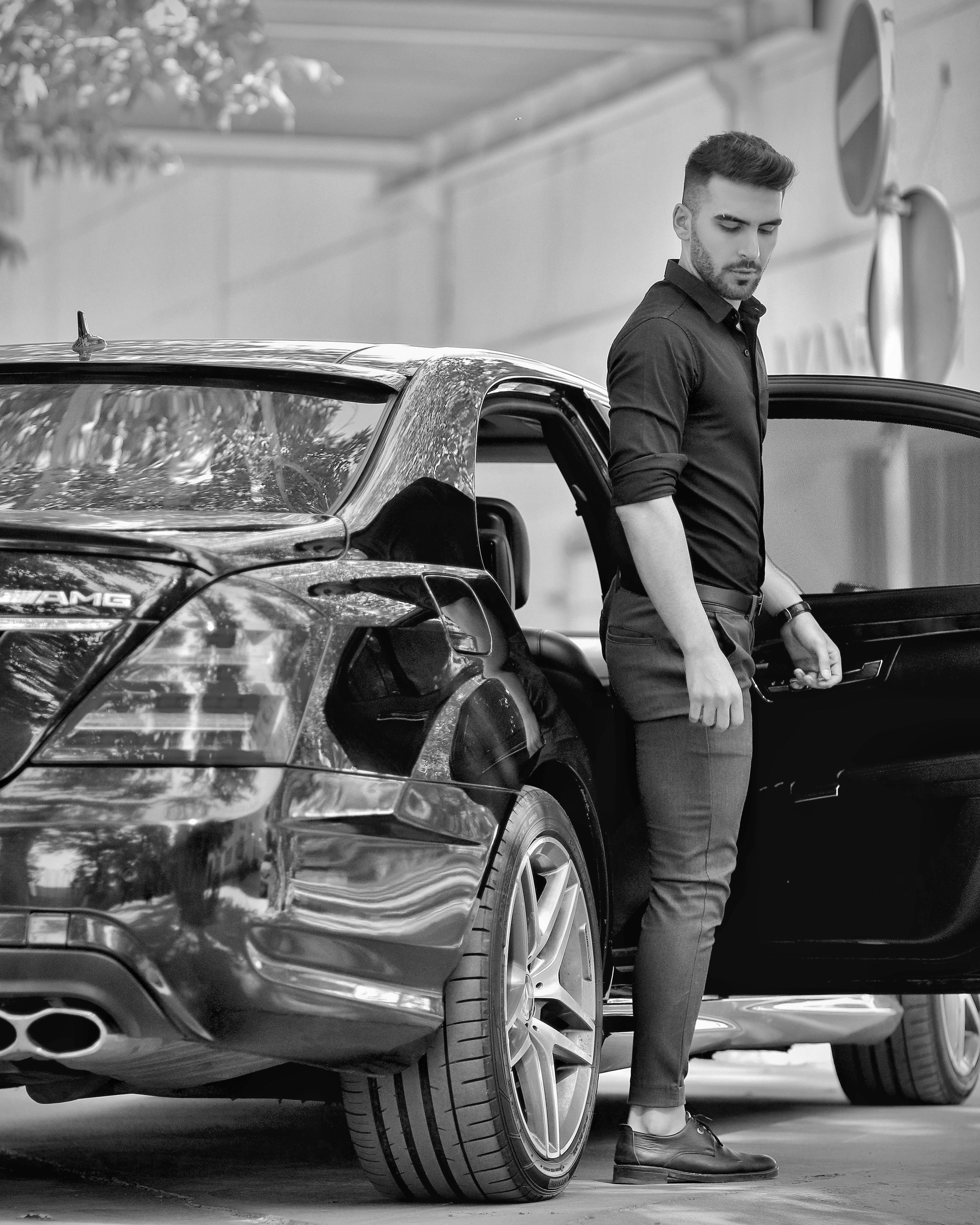 a man standing next to a parked car