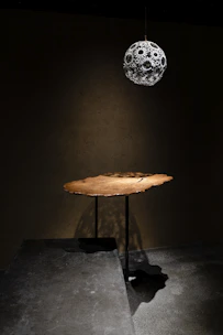 A bohemian macrame light casting intricate shadows over a rustic wooden table