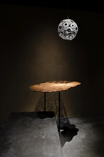 A bohemian macrame light casting intricate shadows over a rustic wooden table