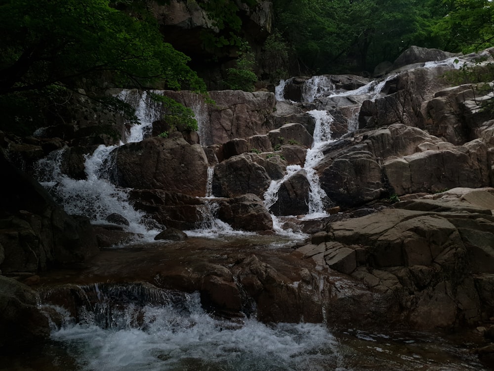 a small waterfall in the middle of a forest