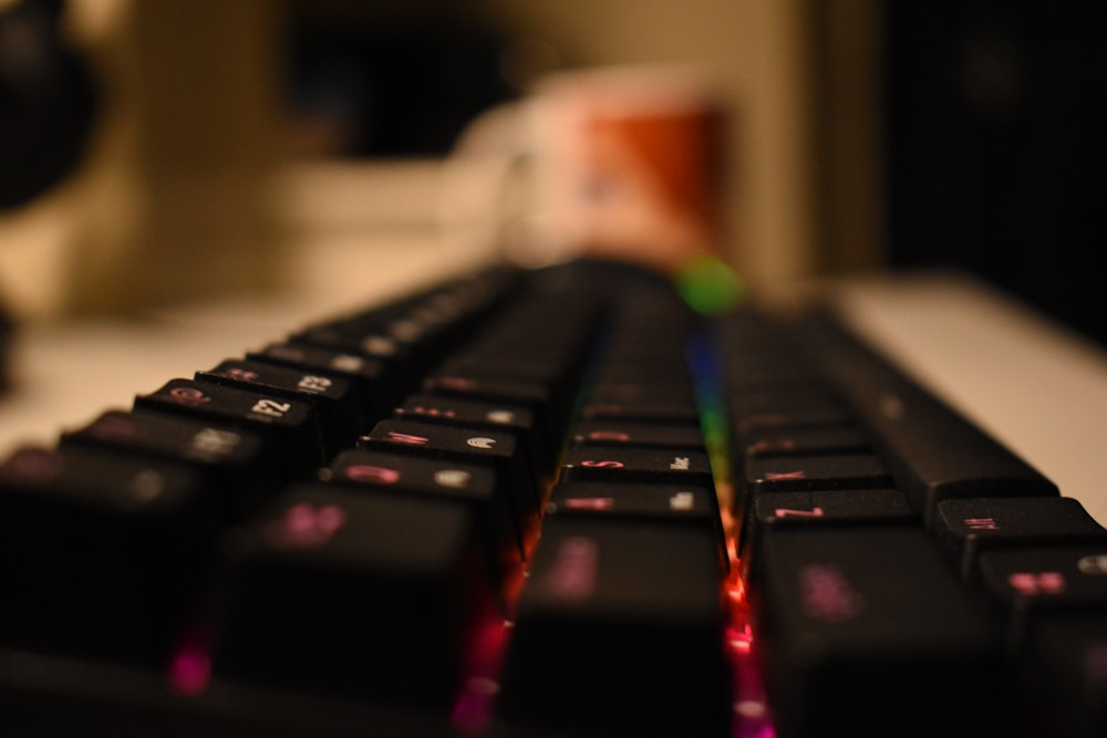 a close up of a keyboard with a rainbow light on it