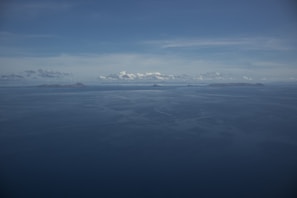 View from the bungalow’s deck showing a calm sea and distant islands under a clear sky.