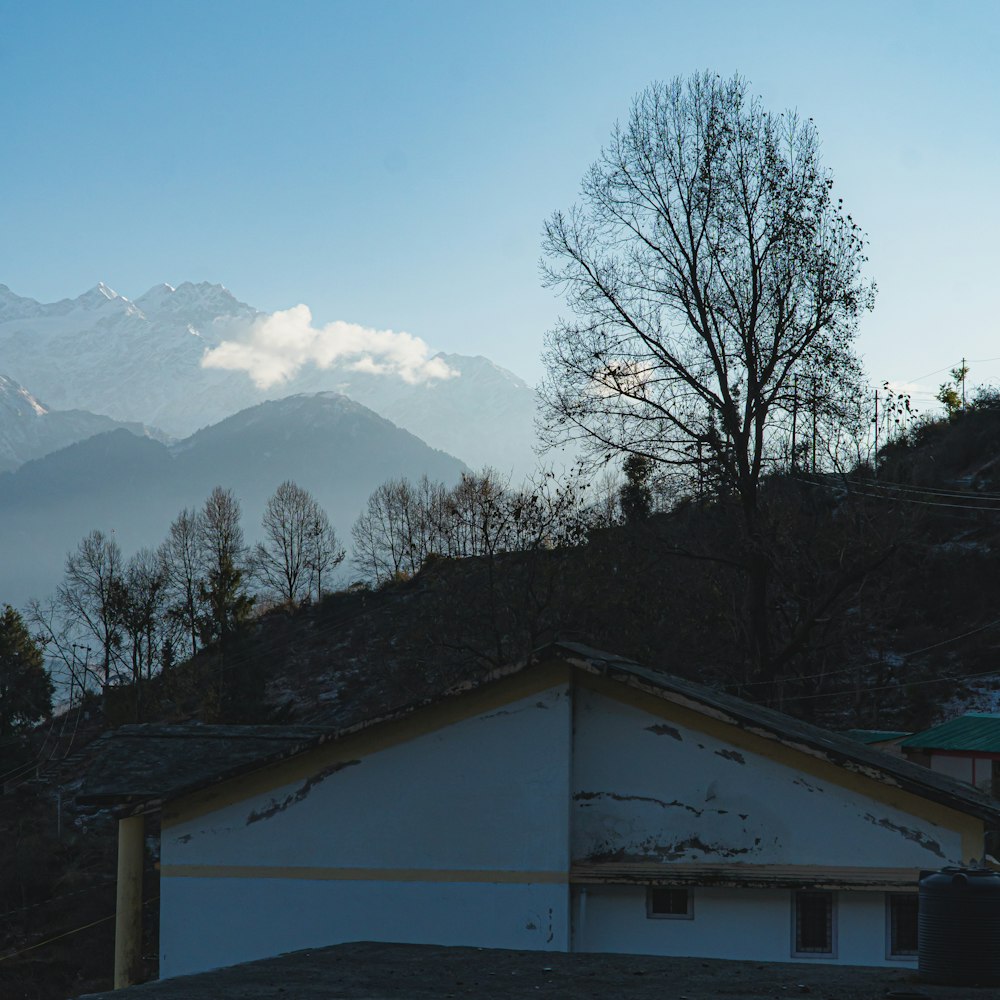 a house on a hill with mountains in the background