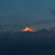 An inspirational photo showing a mountain peak piercing through low clouds.