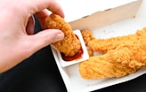 a person is dipping something into a container