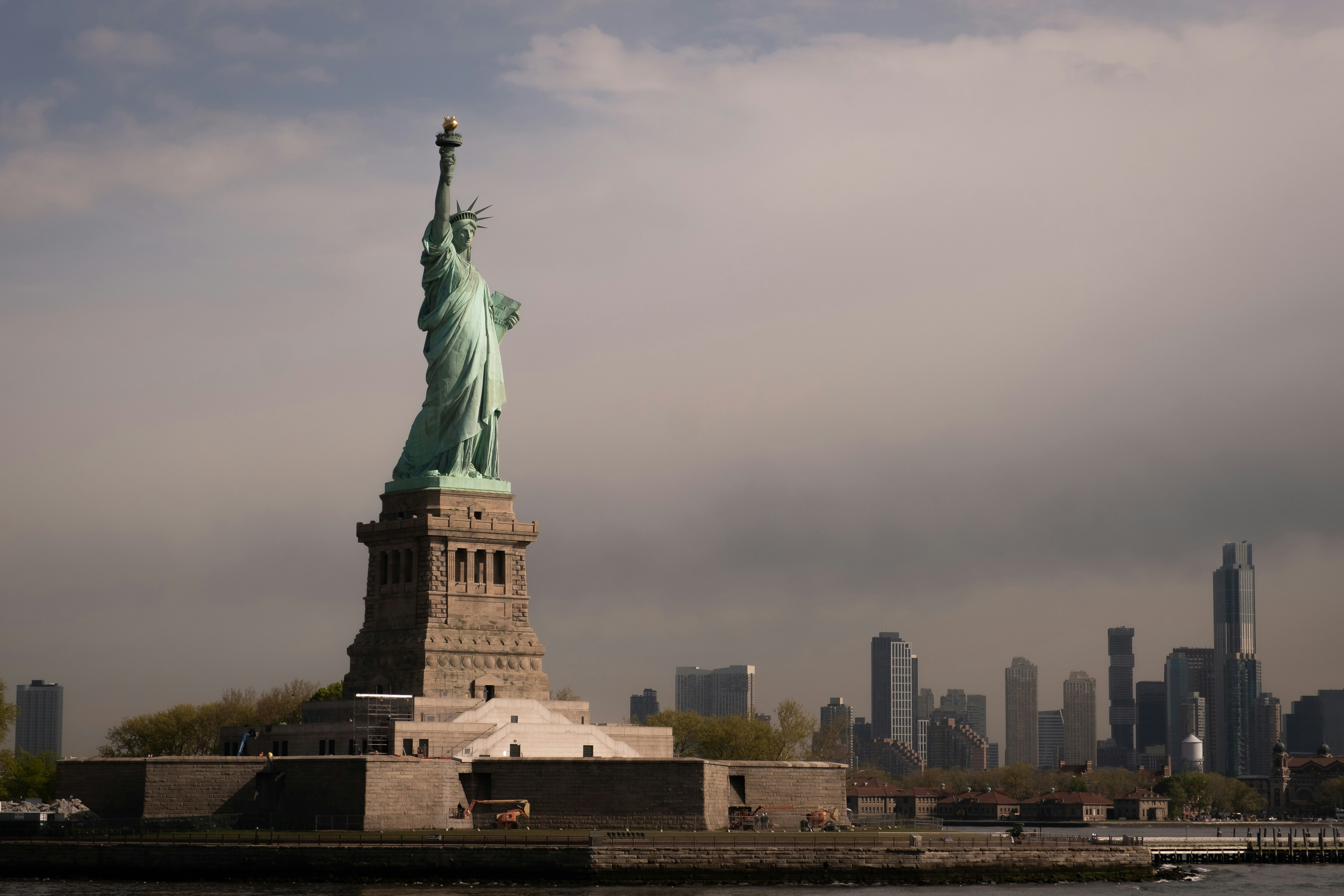 the statue of liberty stands in front of the city skyline