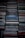 A collection of stacked CD cases, neatly organized in rows with visible labels and album information. The cases exhibit a range of colors and some wear, suggesting a diverse music collection.
