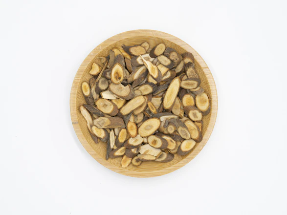 Close-up of natural botanical ingredients arranged on a wooden table with a certification document nearby.