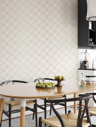 A stylish dining area with a wooden table, black chairs, and subtle gold decorative elements.