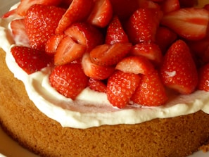 A tempting dessert of chocolate cake topped with fresh strawberries and a drizzle of cream