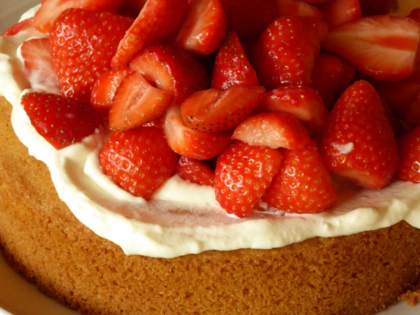 A close-up of a creamy chocolate cake with fresh strawberries on top
