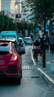 A calm city street with emergency vehicles in the distance at dusk.