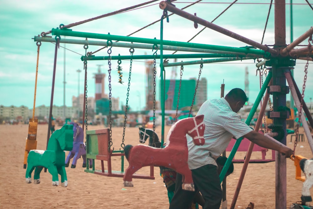 a man on a swing set with a dog