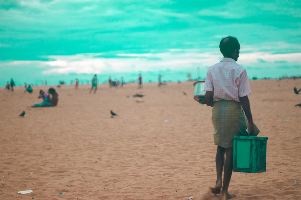 a man walking on the beach with a suitcase