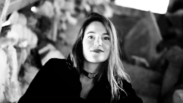 Portrait of Stella smiling warmly against a backdrop of the Mediterranean Sea.