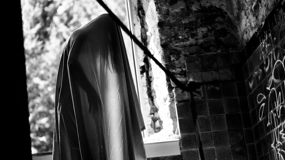 Una foto in bianco e nero di una vestaglia appesa a una linea di vestiti