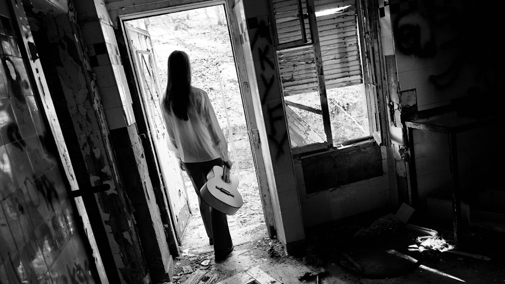 Una mujer parada en una puerta de un edificio deteriorado