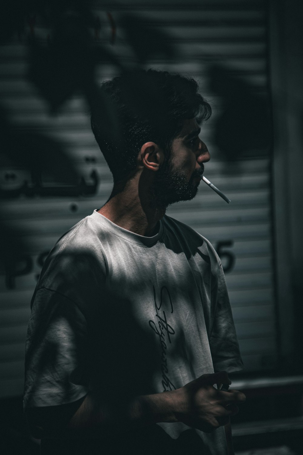 a man smoking a cigarette in a dark room