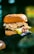 A gourmet hamburger with a glossy bun, topped with lettuce and wrapped in gold foil, held in a hand wearing a black glove, set against a blurred background.
