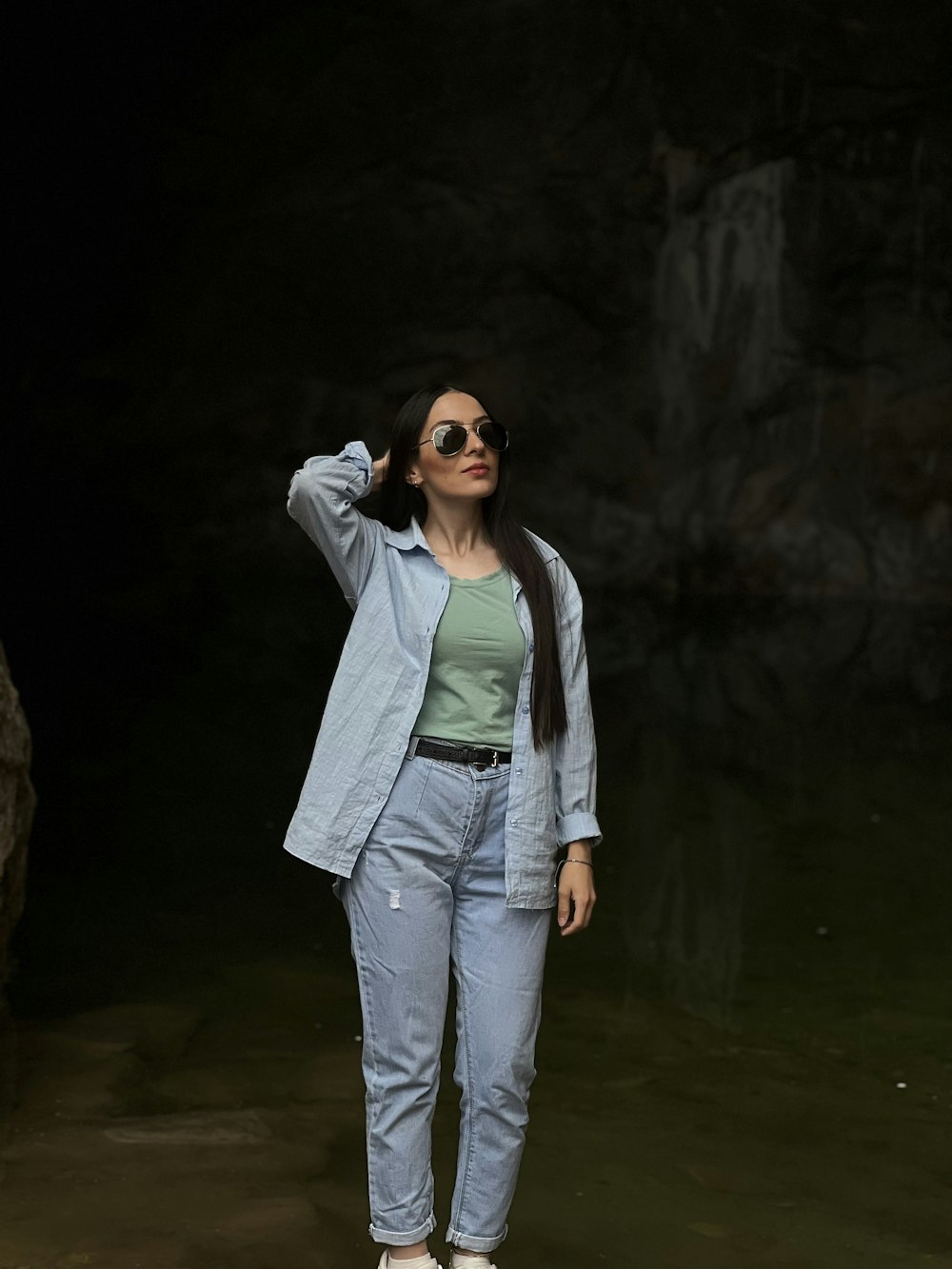 a woman standing in the water wearing sunglasses