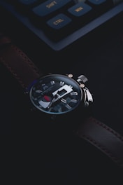 Close-up of a finely crafted luxury watch with royal bee branding on a dark background.