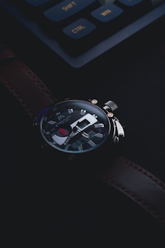 Close-up of a finely crafted luxury watch with royal bee branding on a dark background.